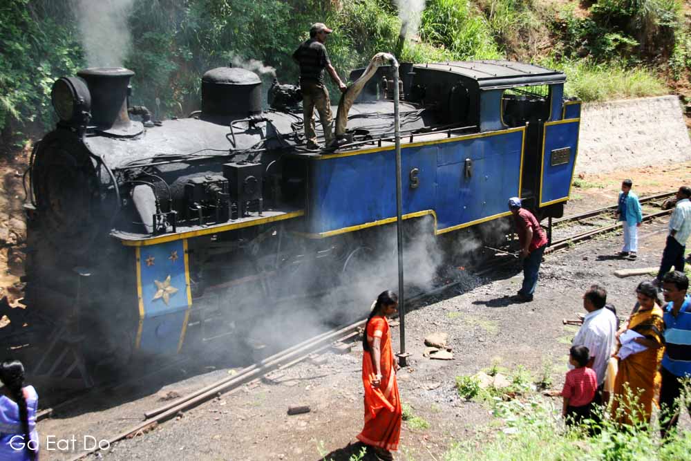 An X Class steam locomotive takes on water on its journey along the Nilgiri Mountain Railway, a UNESCO World Heritage Site in Tamil Nadu, India