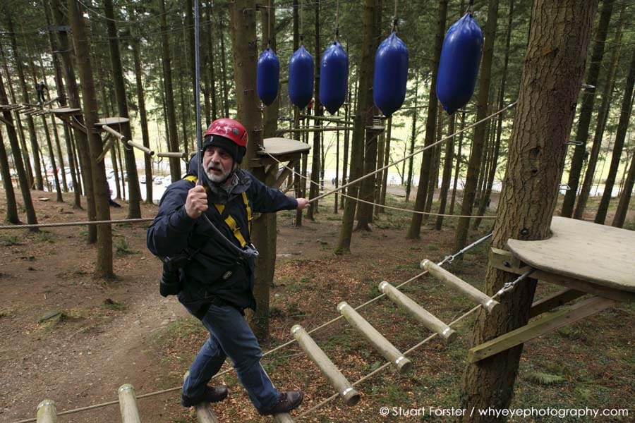 Photographer Geoff Moore climbing on the Adventure Course at Tree Top Adventure in Snowdonia National Park in North Wales