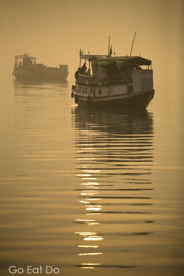 Boats sailing during a golden dawn in the Sunderbans National Park on the border of India and Bangladesh