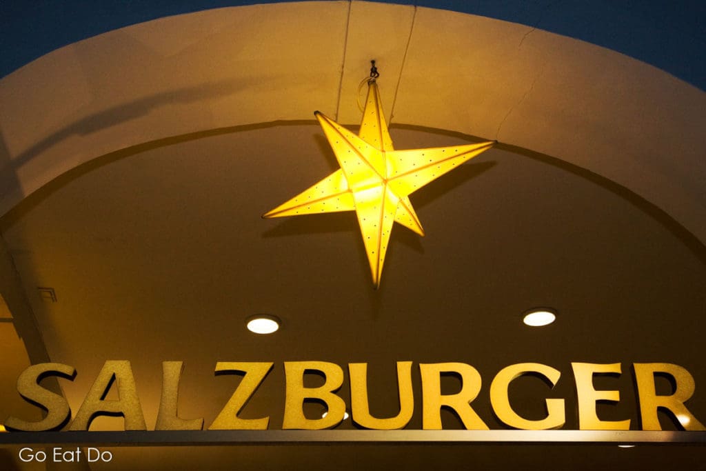 An illuminated star hangs abover a sign for the Salzburger Christkindlmarkt, Salzburg's Christmas market.