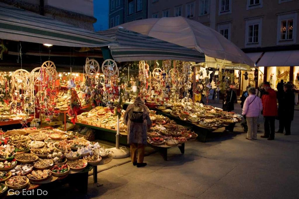 People browsing market stalls in Salzburg's Altstadt district.