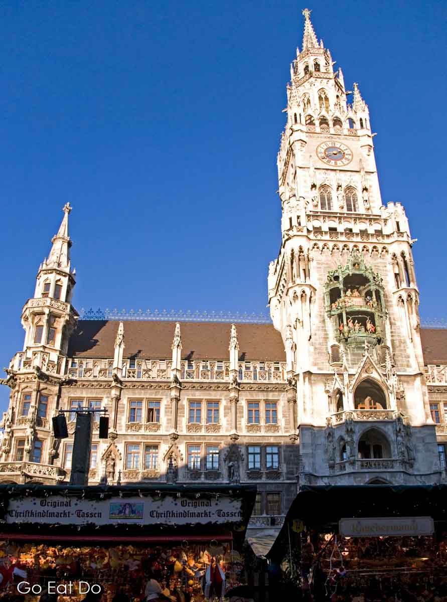 The clock tower of the neo-Gothic Neues Rathaus (New Town Hall) in central Munich rises above stalls of the Marienplatz Christkindlmarkt, the Munich Christmas market in the heart of the city.