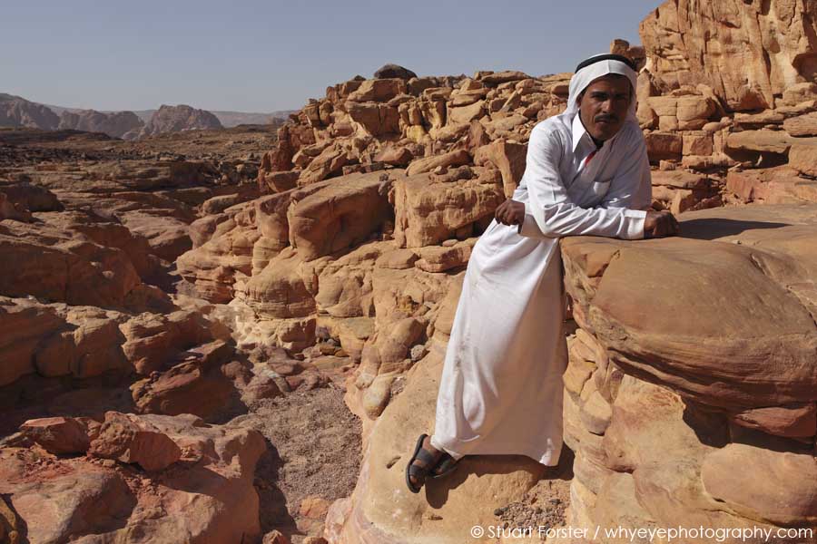 Bedouin guide wearing a traditional costume stands in the Coloured Canyon in the Sinai Desert, Egypt
