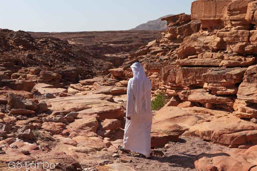 Bedouin guide in traditional clothing walking at the Coloured Canyon in the Sinai Desert, Egypt