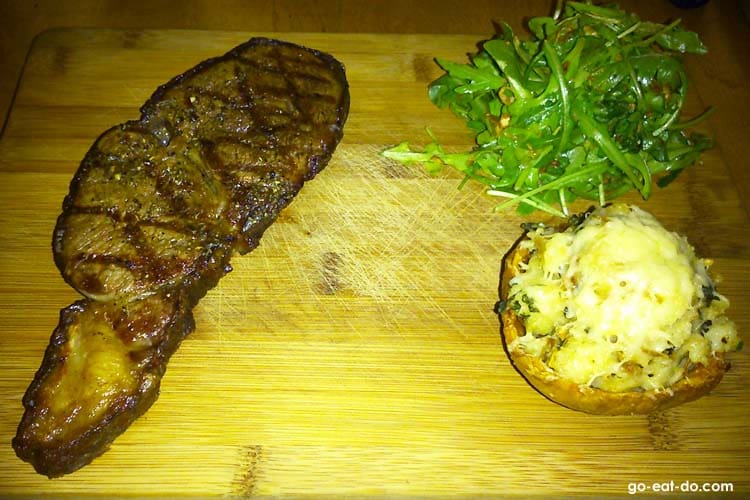 Rib eye steak with twice baked potato and an arugula and arugala salad at Ayden Kitchen and Bar in Saskatoon, Canada