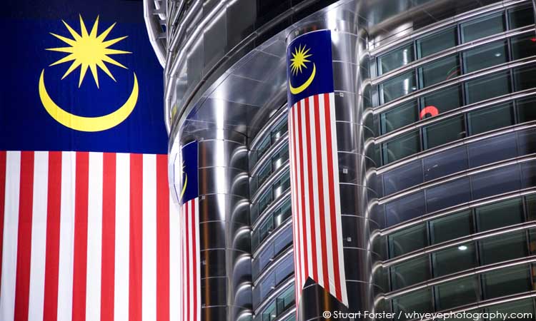 Malaysian flags seen at night hanging from the Petronas Towers in Kuala Lumpur, Malaysia