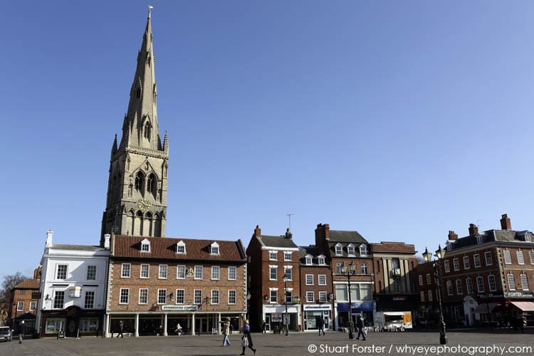 Spire of St Mary Magdalene church rises over building on the market square in Newark-upon-Trent, Nottinghamshire