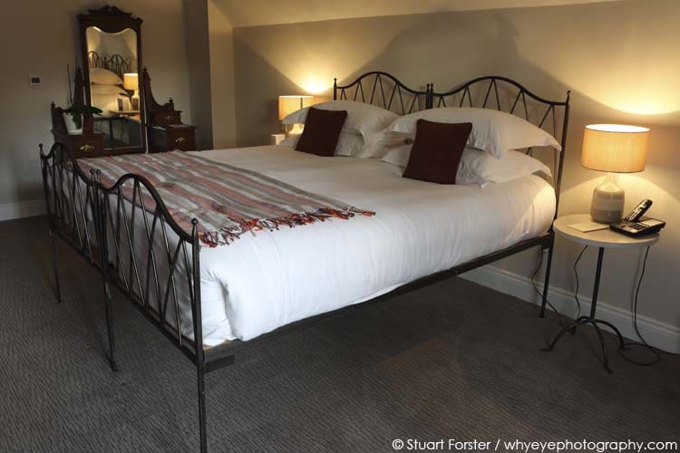 Double bed with a wrought iron frame in a guestroom at St Mary's Inn, in Northumberland