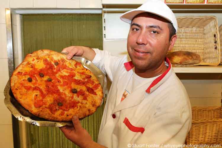 Baker shows off freshly baked focaccia at the Panificio Fiore in Bari, Italy