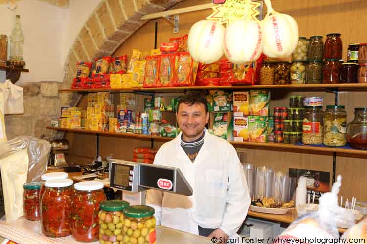 Smiling shopkeeper at the Antica Salumeria delicatessen in Bari, Italy