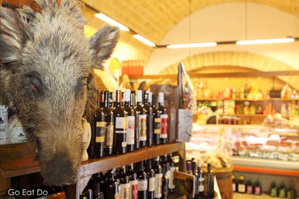 A boar's head, bottles of wine and the delicatessen counter in the Antica Salumeria Del Gusto Italian delicatessen in Bari, Italy.