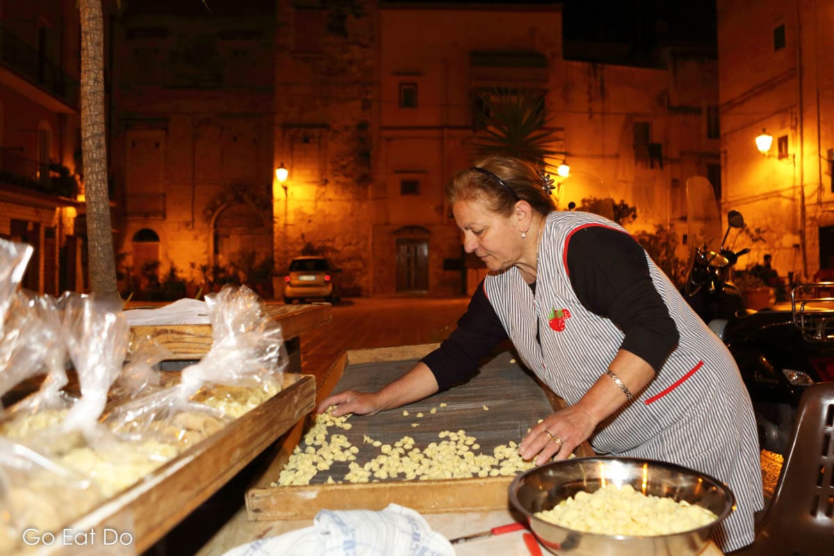 A local woman prepares orecchiette, a pasta shaped like little ears, on a square in Bari, Italy.