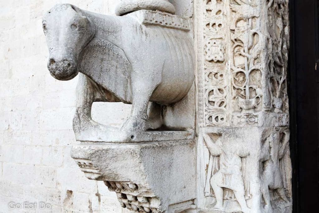 Medieval bull sculpture by the main door of the Basilica of Saint Nicholas in the Old Town of Bari, Italy.