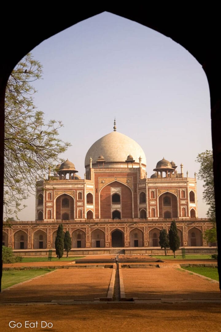 Humayan's Tomb seen through a Mughal arch in Delhi, India.