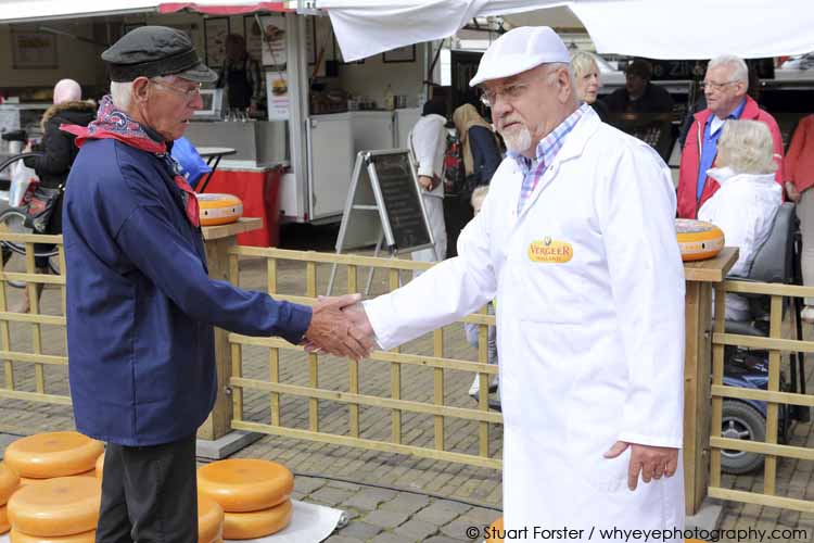 Men slap hands, recreating how negotiations between farmer and merchants were traditionally concluded, at Gouda Cheese Market in Gouda, the Netherlands