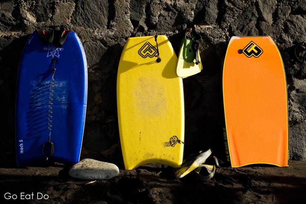 Body boards and flippers by a wall at Taganana Beach in Tenerife