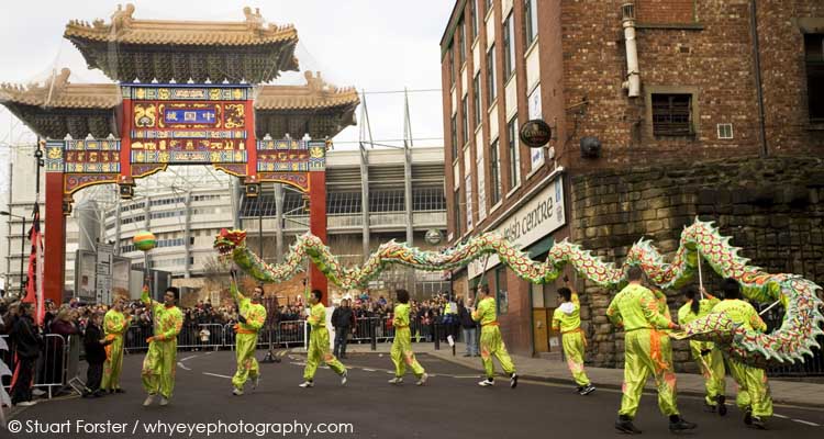 Men perform a dragon dance in front of the gate of Chinatown during Chinese New Year celebrations in Newcastle-upon-Tyne, England