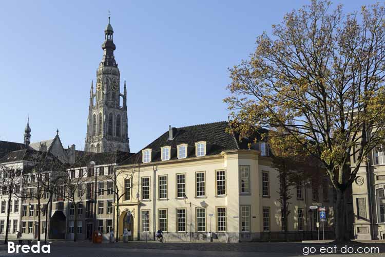 Tower of the Church of Our Lady peeks above buildings on the Kasteelplein in Breda, the Netherlands