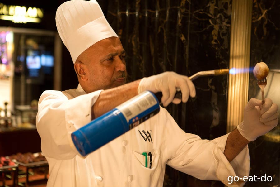 Chef toasting a marshmallow during Sunday brunch at the Waldorf Astoria New York hotel