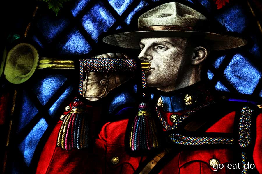 Stained glass window depicting a bugling Mountie.