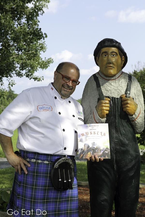 Chef Alain Bossé, the Kilted Chef, displaying a cope of his cookbook, Mussels