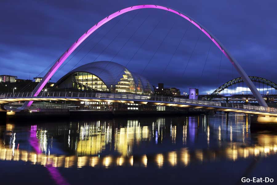 Gateshead Millennium Bridge, illuminated with a pink light, spanning the River Tyne between Gateshead and Newcastle-upon-Tyne, England