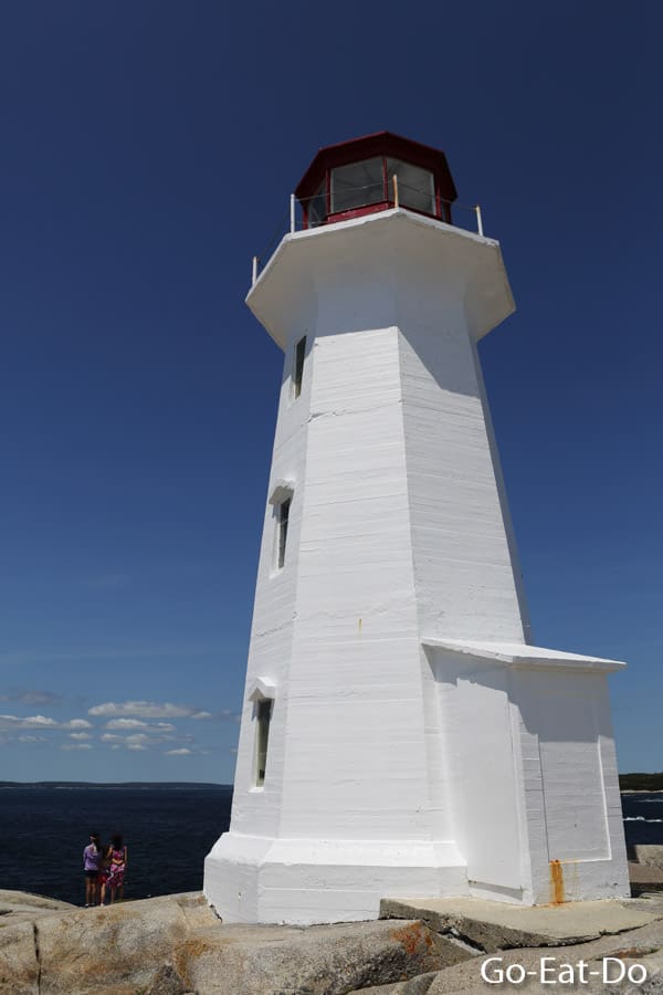 White lighthouse at Peggy's Point under a blue sky on a summer day at Peggy's Cove in Nova Scotia, Canada