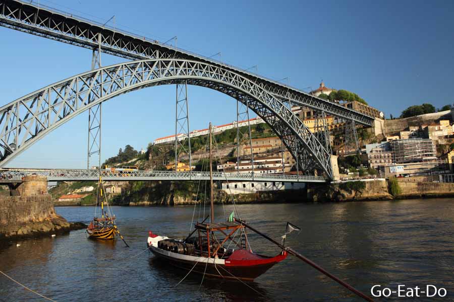 Boat on the Douro River beneath the Dom Luis I Bridge in Porto, Portugal