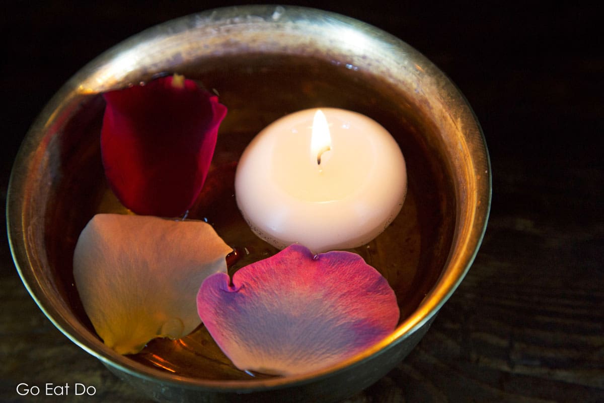A floating candle and rose petals at The Mint Room Indian restaurant, romantic dinner counts among popular date night ideas and this restaurant in Bristol is ideal.