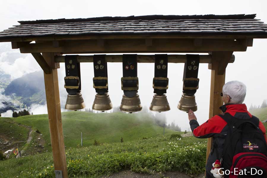 Woman rings cow bells at the Schynige Platte Botanical Alpine Garden near Interlaken, Switzerland