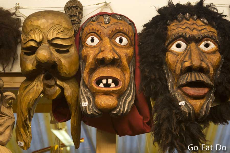Wooden masks, carved by Swiss craftsperson to drive off evil spirits, in Interlaken, Switzerland