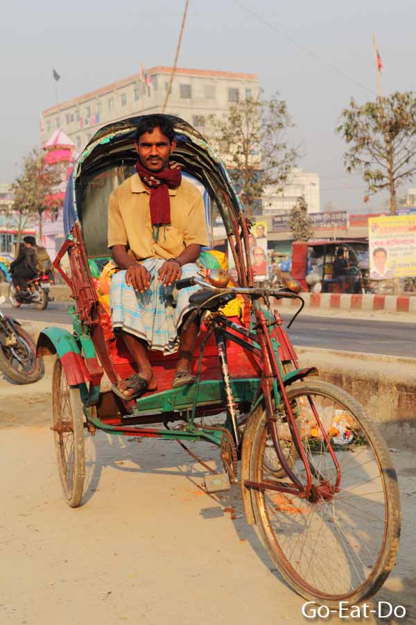 Driver sitting on a bicycle rickshaw in Dhaka, Bangladesh