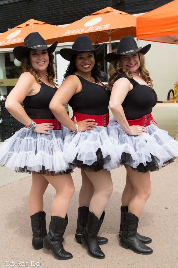 Members of Dance Through Life in tutus, Smithbilt hats and cowboy boots at the Lilac Festival in Calgary, Alberta, Canada