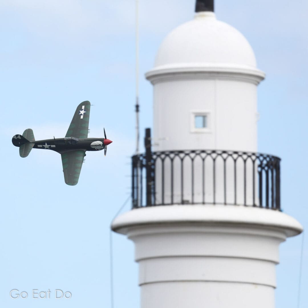 Curtiss P-40 Warhawk (Kittyhawk) flying near Sunderland's White Lighthouse at Roker Cliff Park.