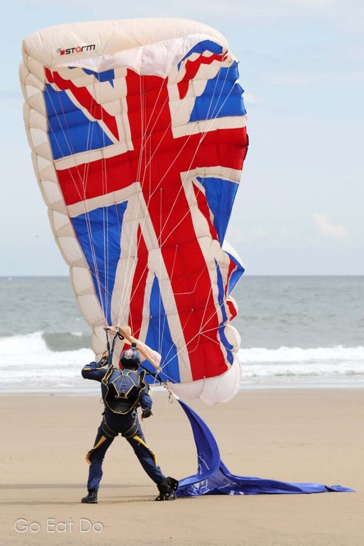 James Bond moment as a member of the British Army's Tigers Parachute Display Team gathers his Union Flag parachute after landing on Seaburn Beach.