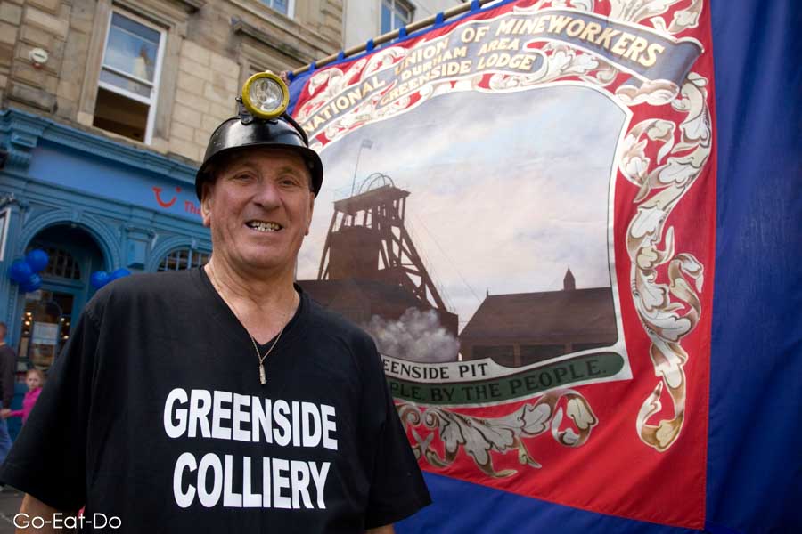 Ex-miner from Greenside Colliery by a National Union of Mineworkers' banner at Durham Miners' Gala