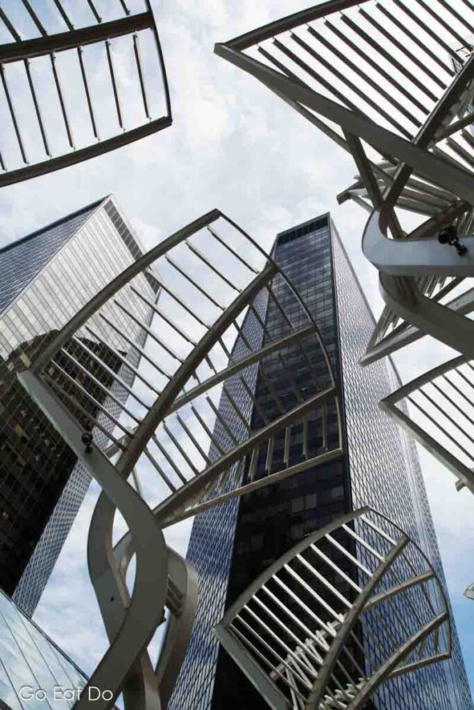 Looking up at high-rise buildings and the Galleria Trees sculpture on 8th Street in Calgary, Alberta.