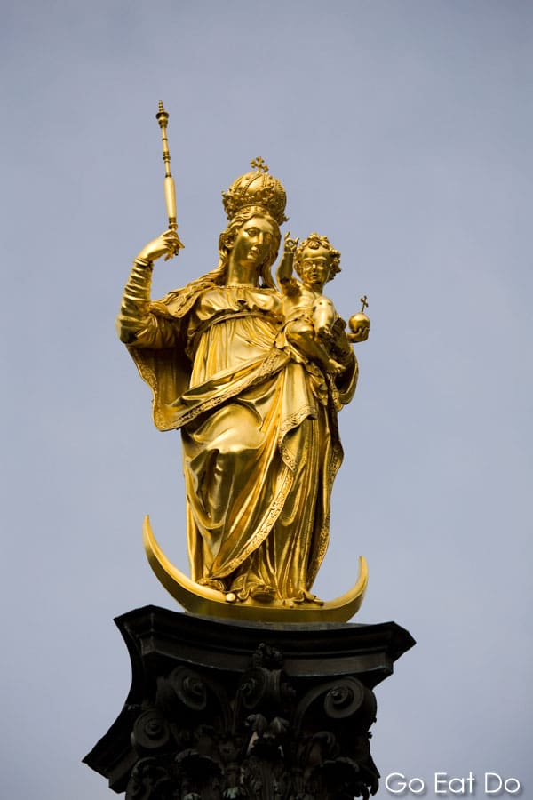 Column with a golden statue of the Virgin Mary holding the Infant Jesus, on Marienplatz, the central point of Munich, Germany