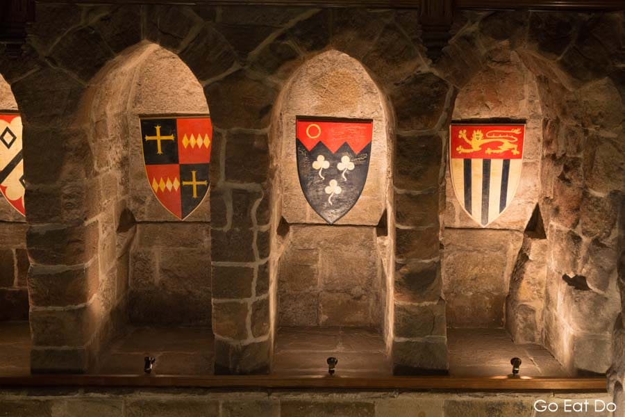 Shields bearing heraldic crests above the garderobe in Langley Castle, a n ideal place for a castle stay UK.