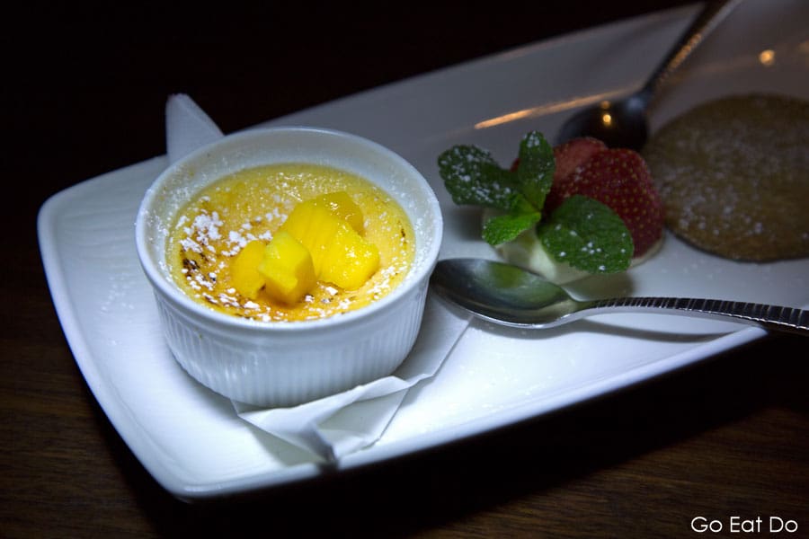 Crème brulee served with mango pieces, cream and sliced strawberry plus lavender shortbread.