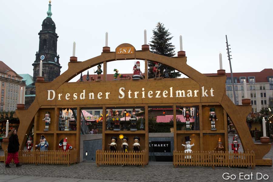 Traditional wooden Räuchermänner figures by the sign at the Striezelmarkt, the Christmas market in Dresden, Germany