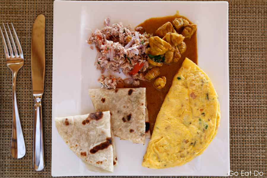 Breakfast of Maldivian chicken curry served with chapatti bread and spicy coconut tuna at the luxury Bandos Maldives resort in the Maldives