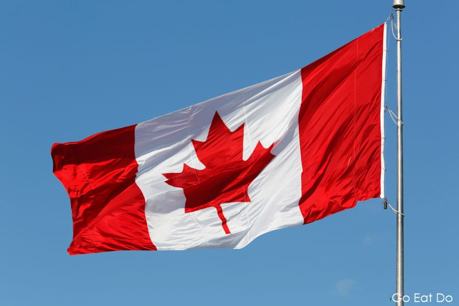 Canadian flag flying in a clear blue sky