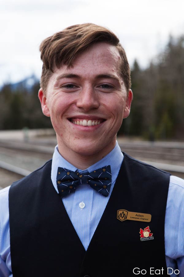 Smiling member of staff aboard the Rocky Mountaineer luxury train in western Canada
