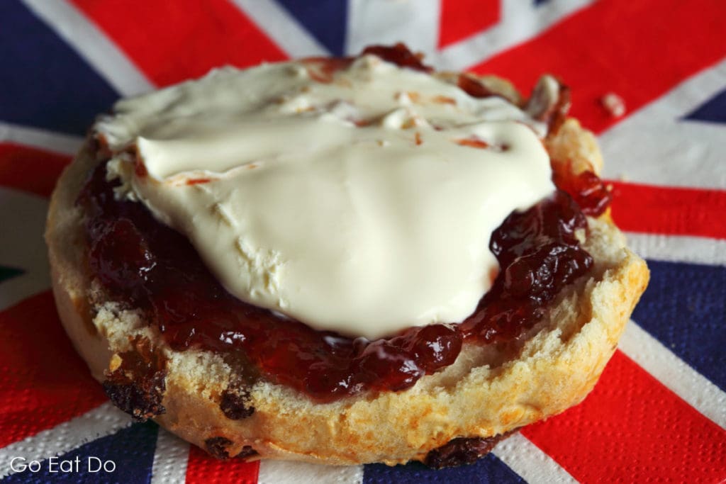 Scone with strawberry jam and clotted cream on a Union Jack serviette.