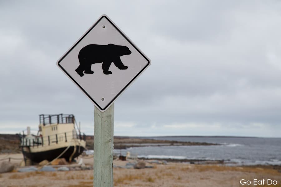 Warning sign for polar bears by the Beluga, a boat by the shore of the Hudson Bay, at Churchill in Manitoba, Canada