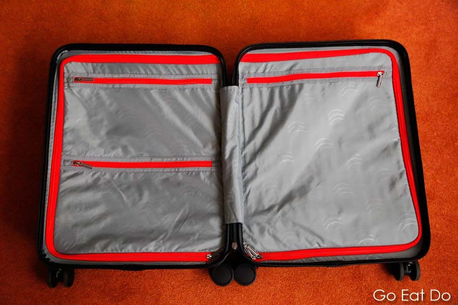 The lined interior of a Bizhop suitcase with pockets for packing clothing, toiletries and a laptop computer