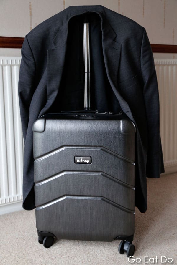 Man's jacket and hung on the extendable handle of Bizhop business suitcase