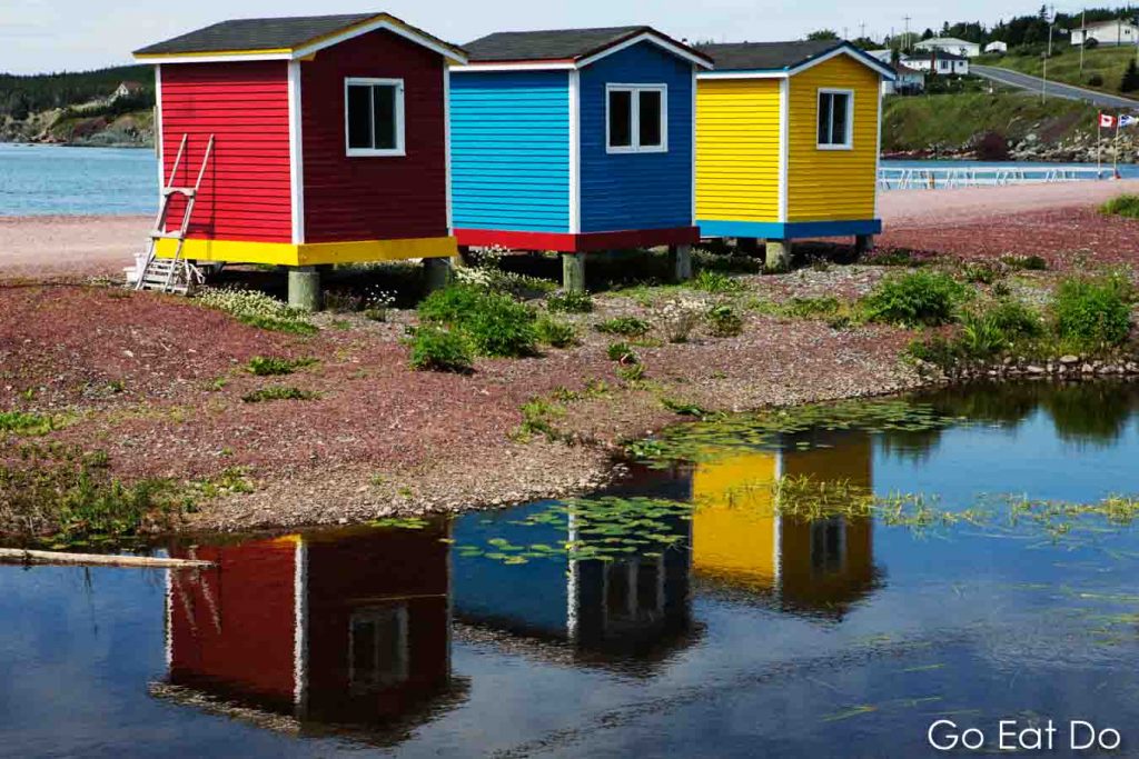Colourfully painted beach huts reflecting in a pond at Heart's Delight-Islington in Newfoundland and Labrador, Canada