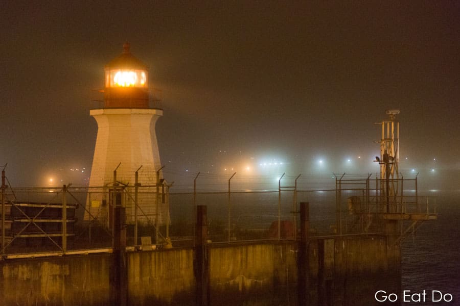 Lighthouse shining on a foggy night at the waterfront in Saint John, New Brunswick